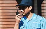 Security guard, walkie talkie and safety officer man outdoor for protection, patrol and communication. Law enforcement, serious and crime prevention worker with sunglasses, uniform and radio in city