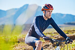 Fitness, countryside or man cycling on a mountain bike for training, cardio workout or exercise outdoors. Serious, healthy biker or sports athlete riding a bike on a path for wellness or challenge