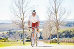 Fitness, countryside or man cycling on a bicycle for training, cardio workout and exercise outdoors alone. Wellness, healthy or sports athlete riding a bike on a road or path for freedom or challenge