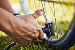 Fixing, bicycle and a man with air in wheel for maintenance, safety or repair while cycling. Bike, hands and a sports person or athlete with a pump or tools for flat tire or broken transportation