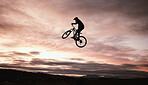Sunset, dirt bike and jump with action in outdoor with sport in nature for adventure or risk. Motorcycle, silhouette and freedom with training or sky with speed in desert with person driving.