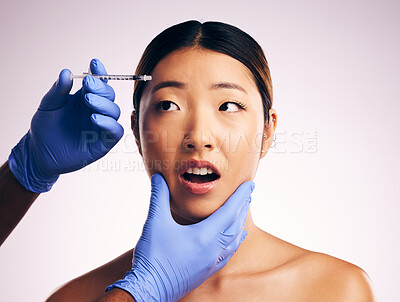 Buy stock photo Woman, needle and fear on face in studio for surgery, cosmetics and shock with collagen by white background. Japanese patient, doctor and syringe for dermatology, change and pain for skin aesthetic