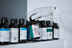Scientist hand, bottle and chemical on shelf in pharma lab for analysis, results or medicine development. Science person, gloves and study with medical research for pharmaceutical industry innovation