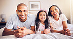 Family, relax and portrait on a bed at home while happy and together for quality time. Man, woman or hispanic parents and a girl kid in the bedroom for morning bonding with love, security and care
