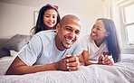 Mother, father and child laughing on a bed in a family home while happy and playing for quality time. Man, woman or parents and girl kid together in the bedroom for morning bonding with love and care