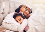 Family, portrait of a girl in bed with her parents and morning with adorable little child in the bedroom at home. Face, smile or happy with a young female kid in the house to relax with mom and dad