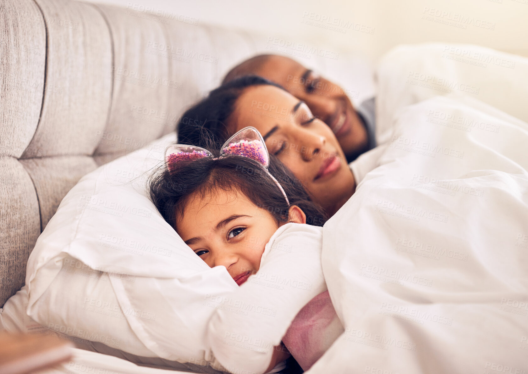 Buy stock photo Family, portrait of a girl in bed with her parents and morning with adorable little child in the bedroom at home. Face, smile or happy with a young female kid in the house to relax with mom and dad