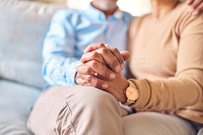 Buy stock photo Love, support and a senior couple holding hands while sitting on a sofa in the living room of their home during retirement. Trust, relax or affection with an elderly man and woman bonding together