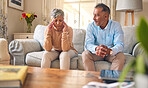 Senior couple, fight and divorce in stress, conflict or argument from disagreement on living room sofa at home. Elderly man and woman in depression, infertility or toxic relationship in the house
