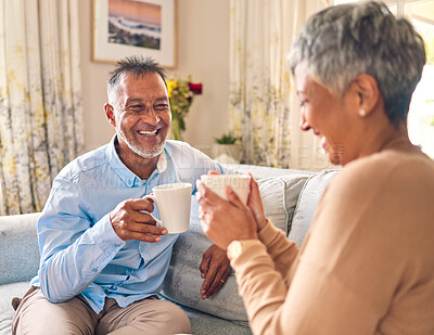 Buy stock photo Coffee, laughing and a senior couple on a sofa in the home living room to relax while bonding in conversation. Smile, retirement or love with a mature married man and woman talking while drinking tea