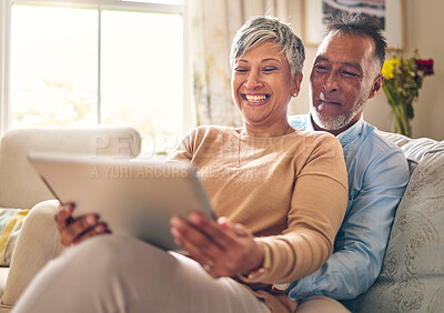 Buy stock photo Happy, streaming and a couple with a tablet on the sofa for communication, social media or online chat. Smile, house and a senior man and woman with a movie on technology on the couch and laughing