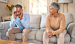 Senior couple, stress and divorce in fight, conflict or argument for disagreement on living room sofa at home. Elderly man and woman in depression, infertility or toxic relationship in the house