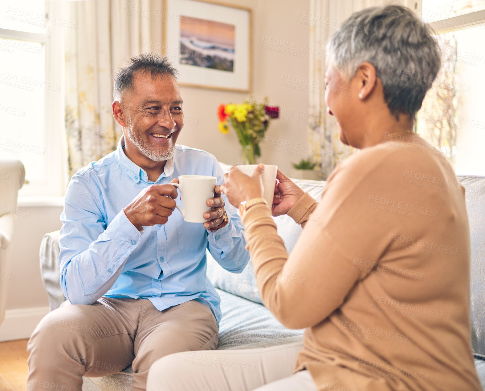 Buy stock photo Coffee, smile and a senior couple on a sofa in the home living room to relax while bonding in conversation. Love, retirement or marriage with a mature man and woman talking while drinking a beverage