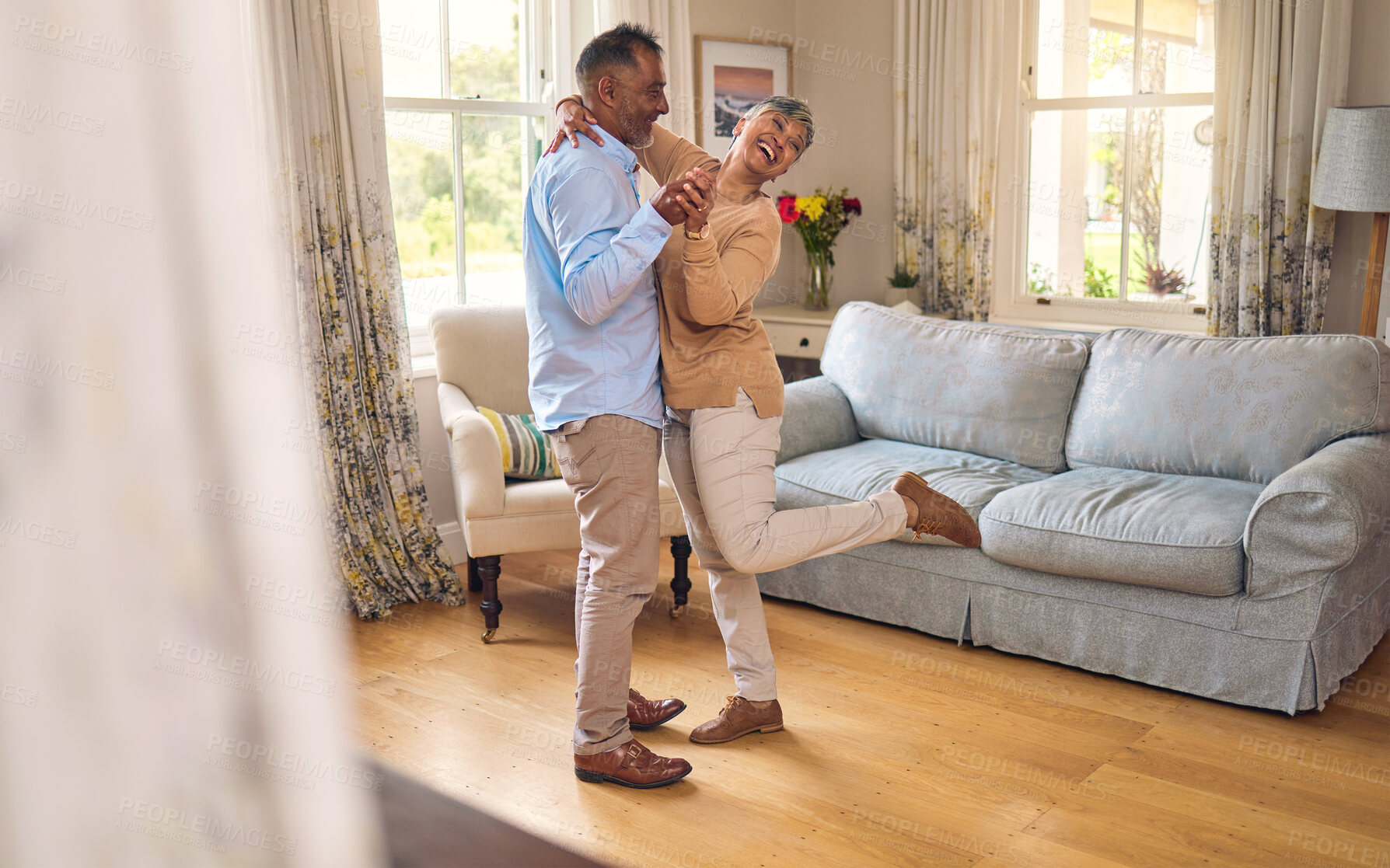 Buy stock photo Love, funny and dance with a senior couple in the living room of their home together for bonding. Marriage, retirement or romance with an elderly man and woman laughing in the lounge of their house