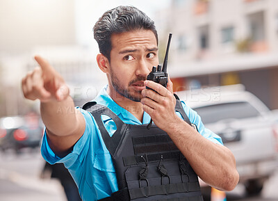 Buy stock photo Man, police and pointing with walkie talkie in city for emergency dispatch, arrest or calling suspect. Male person, cop or law enforcement in radio signal for communication and safety in town street