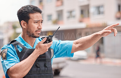 Buy stock photo Asian man, police and pointing with walkie talkie in city for emergency dispatch, arrest or calling suspect. Male person, cop or law enforcement with radio signal for communication or safety in town