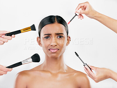 Buy stock photo Makeup, brush and anxiety, woman with beauty shine and overwhelmed with beautician on white background. Doubt with cosmetics, tools and hands crowd female model in studio, cosmetology and skin glow