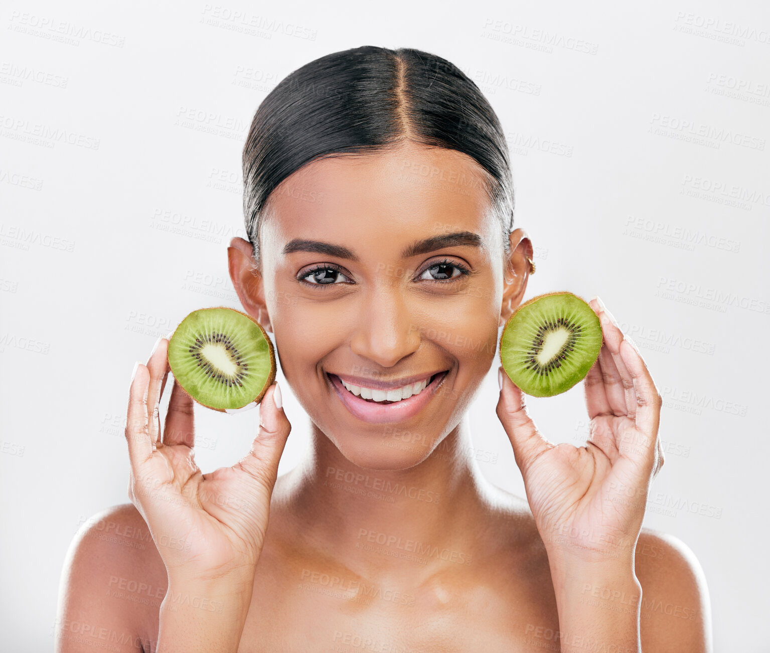 Buy stock photo Skincare, health and portrait of a woman with kiwi for nutrition, diet and wellness. Happy, spa treatment and an Indian girl or model with fruit or food for facial isolated on a white background
