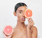 Indian woman, portrait with grapefruit for beauty, skincare and natural cosmetics for healthy glow, citrus or vitamin c. Face, emoji and skin care with fruit for wellness, health and white background