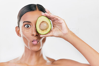 Buy stock photo Woman, avocado and funny studio portrait for health, wellness and diet for facial glow by white background. Girl, model and fruit for skincare, nutrition or cosmetics with comic expression for beauty