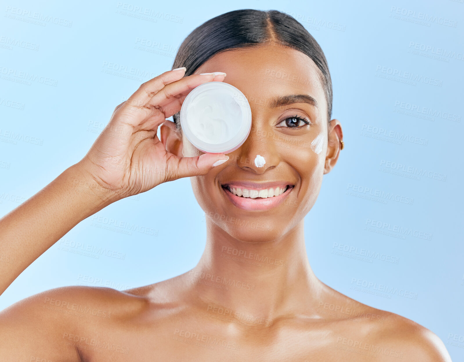 Buy stock photo Cream, container and beauty, woman with skincare and cosmetics product isolated on blue background. Lotion on face, sunscreen and facial mask, smile and moisturizer with female model and dermatology