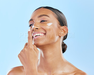 Buy stock photo Beauty, face cream and skin of a happy woman with natural glow on a blue background. Dermatology, moisturizer and cosmetics of an Indian female model for facial shine, wellness or self care in studio