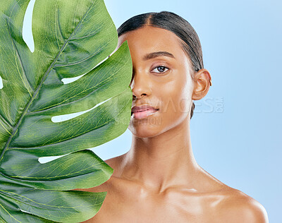 Buy stock photo Skincare, plant and portrait of a woman on a blue background for skincare, wellness and beauty glow. Ecology, dermatology and an Indian girl or model with a leaf isolated on a studio backdrop