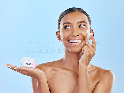 Buy stock photo Face, cream in hand and beauty, woman with skincare and cosmetics product isolated on blue background. Lotion, sunscreen and facial mask, smile and moisturizer with female model and dermatology