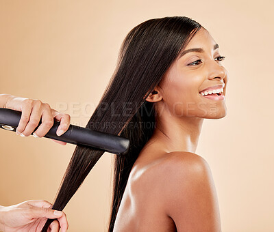 Buy stock photo Flat iron, beauty and hair care of a woman in studio with hands of a stylist. Straightener, cosmetics and wellness of Indian person for hairdresser, hot tools or salon results on a beige background
