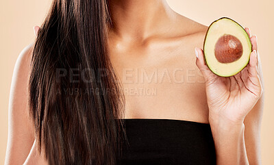 Buy stock photo Closeup, woman and avocado for hair, beauty or cosmetic treatment for natural growth, shampoo cosmetics or studio background. Female model, green fruits or vegan dermatology of healthy hairstyle care