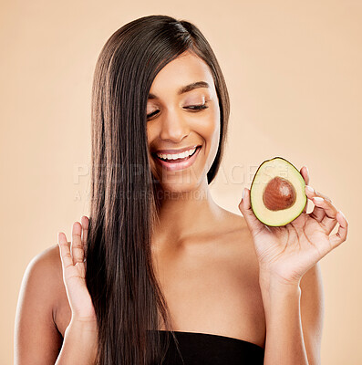 Buy stock photo Smile, woman and avocado for hair care, beauty or cosmetic treatment of natural growth on studio background. Happy indian female model, green fruits and vegan dermatology for healthy keratin benefits