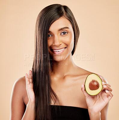 Buy stock photo Portrait, woman and avocado for hair, beauty or cosmetic treatment of natural growth on studio background. Happy indian female model, green fruits and vegan dermatology for keratin and aesthetic glow