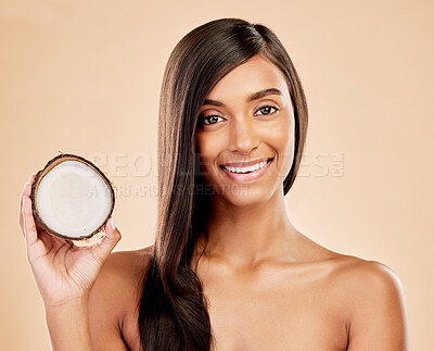Buy stock photo Portrait, woman and coconut for hair, beauty or cosmetic treatment for natural skincare on studio background. Happy indian female model with tropical fruits for hairstyle, aesthetic benefits or shine