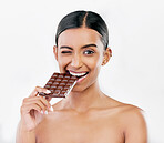 Happy woman, chocolate and candy bite for diet or unhealthy eating against a white studio background. Portrait of female person or model with cocoa slab, block or bar for snack or diabetes on mockup