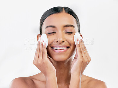 Buy stock photo Woman, smile and cotton pad for face, cosmetics and aesthetic skincare in studio on white background. Happy indian female model with beauty products for cleaning, facial dermatology or makeup removal