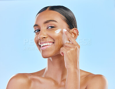 Buy stock photo Face, cream and beauty, woman in portrait with skincare and cosmetics product isolated on blue background. Lotion, sunscreen and facial mask, smile and moisturizer with female model and dermatology