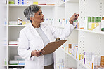 Pharmacy, writing and clipboard of woman with medicine on a shelf for pharmacist inventory. Mature female employee in healthcare, pharmaceutical and medical industry reading information on stock
