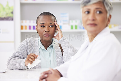 Buy stock photo Consultation, pharmacy and a black woman with a headache and a doctor for healthcare advice. Support, pharmacist and an African patient at a clinic with a migraine and medical worker for help