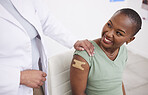 Doctor, patient and plaster on arm for vaccine, medicine and protection for virus with happy black woman in clinic. Medic, african girl and smile for helping hand, injection and strong immune system