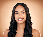 Portrait, hair and smile with a model woman in studio on a brown background for shampoo treatment. Beauty, salon and haircare with a happy young person looking confident about natural cosmetics