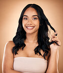 Portrait, hair and aesthetic with a model woman in studio on a brown background for shampoo treatment. Beauty, salon and smile with a confident young person looking natural after cosmetic haircare