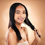 Portrait, hair and shampoo with a model woman in studio on a brown background for keratin treatment. Face, salon and smile with a happy young person looking confident about haircare cosmetics