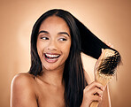Hair care, brush and excited woman with beauty in studio isolated on a brown background. Salon, happy and model with wood grooming product for natural aesthetic, hairdresser or hairstyle for wellness