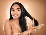 Hair care, comb and portrait of woman, smile and isolated on a brown background in studio. Salon, face and beauty of model with a product for natural aesthetic, hairdresser and hairstyle for wellness