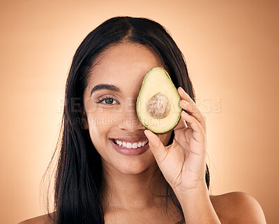Buy stock photo Happy, face and woman with avocado for skincare isolated on a brown background in studio. Portrait, fruit and model with food for nutrition, skin health and vegan diet, omega 3 or natural cosmetics