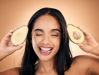 Buy stock photo Face, tongue out and woman with avocado for skincare isolated on a brown background in studio. Fruit, funny and happy model with food for nutrition, health or vegan diet, omega 3 or natural cosmetics