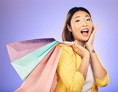 Buy stock photo Asian woman, surprise and shopping bag with retail and fashion, commercial and sale on purple background. Wow for discount at boutique, happy female customer and market with store promotion in studio