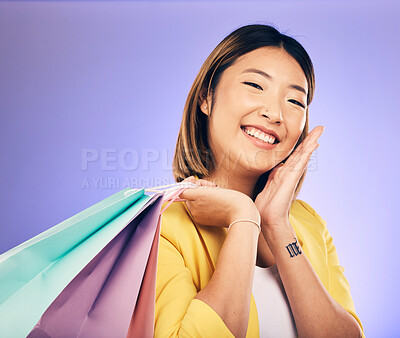 Buy stock photo Smile, portrait and woman with shopping bag, retail and commerce with fashion sale on purple background. Discount at boutique shop, Asian female customer and market with store promotion in studio