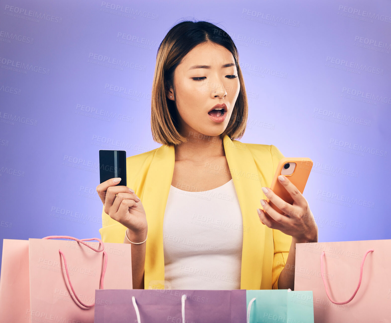Buy stock photo Credit card, phone and woman stress, surprise or shocked for online shopping scam, news or fintech payment problem. Wow, retail bag and asian person for e commerce mistake on purple studio background