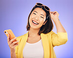 Happy asian woman, portrait and phone in fashion for communication against a purple studio background. Female person or model with smile for networking or stylish clothing on mobile smartphone app